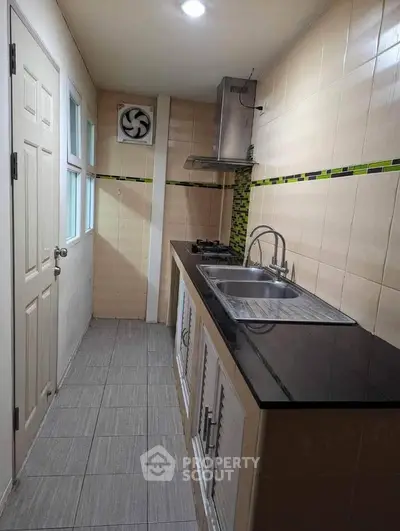 Compact kitchen with modern gas stove and sleek black countertop