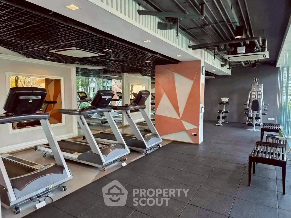 Modern gym with treadmills and exercise equipment in a stylish real estate property.