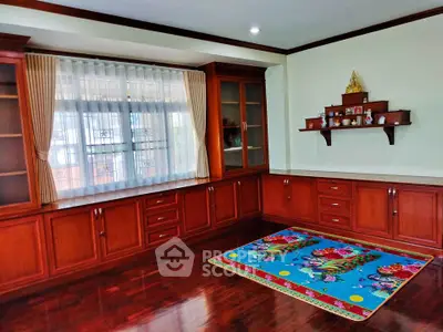 Spacious living room with elegant wooden cabinetry and colorful rug