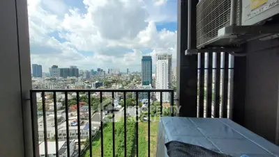Stunning cityscape view from a high-rise balcony with lush greenery and modern skyline.