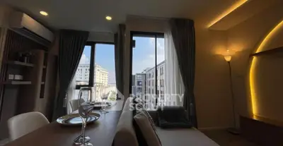 Stylish modern living room with elegant dining setup and city view.