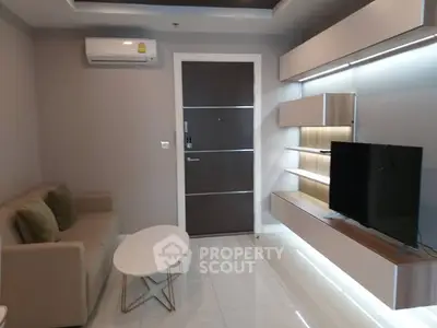 Modern living room with sleek furniture and wall-mounted TV in a stylish apartment.