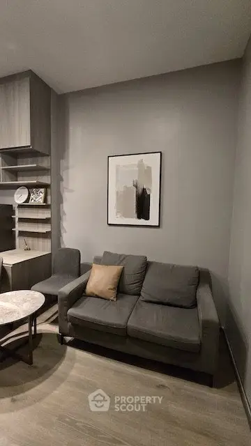 Modern living room with stylish gray sofa and abstract wall art