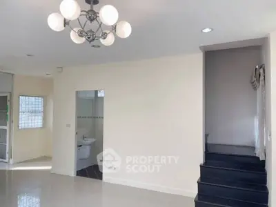 Modern interior with staircase and elegant lighting in a spacious living area.