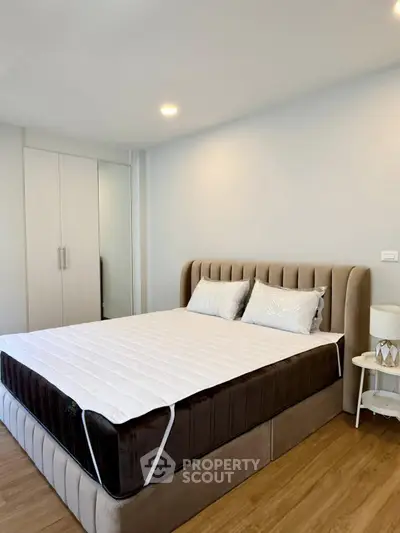 Modern bedroom with plush bed and sleek wardrobe in a stylish apartment.