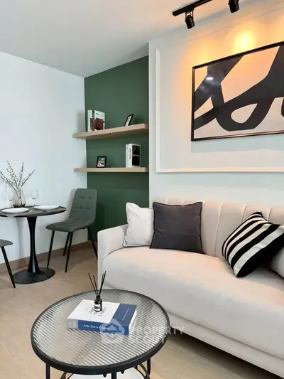 Modern living room with stylish decor, featuring a cozy sofa, chic artwork, and elegant shelving.