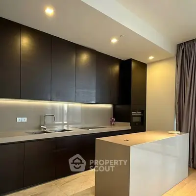 Modern kitchen with sleek dark cabinets and minimalist island