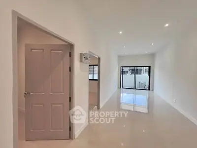 Spacious modern living room with glossy floors and large windows for natural light.