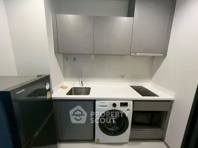 Modern compact kitchen with integrated appliances and sleek cabinetry