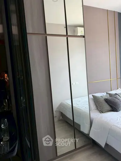 Modern bedroom with stylish mirrored wardrobe and elegant bedding