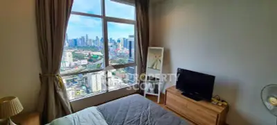 Modern bedroom with stunning city view from large window, featuring cozy decor and natural light.
