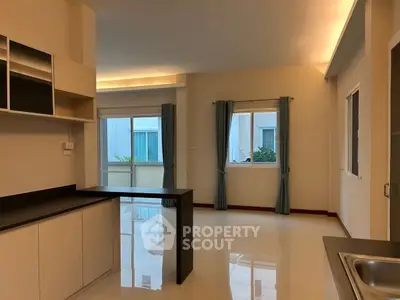 Spacious open-plan living area with modern kitchen and large windows for natural light.