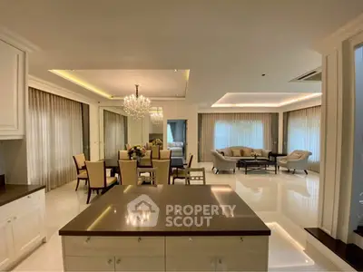 Luxurious open-plan living and dining area with elegant chandelier and modern furnishings.