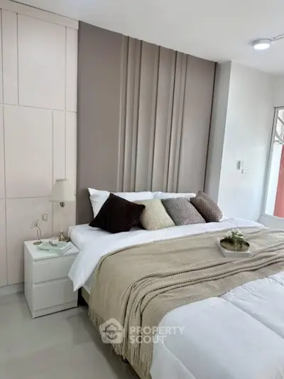 Modern bedroom with stylish decor and cozy bedding in a contemporary apartment.