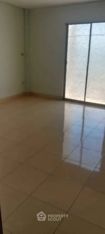 Spacious empty room with tiled floor and sliding glass door