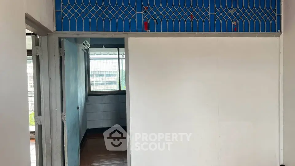 Spacious interior with tiled flooring and large window offering natural light, ideal for customization.