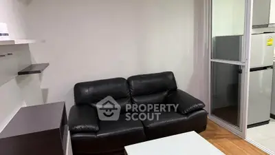 Modern living room with black leather sofa and sleek shelving