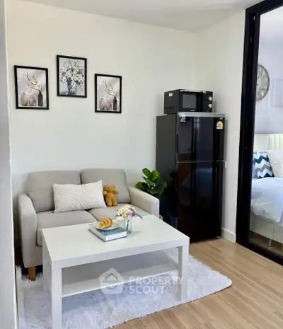 Cozy living room with modern decor and compact kitchen appliances, perfect for urban living.