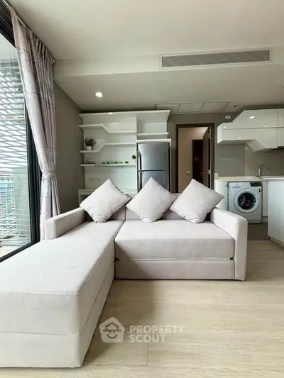 Modern living room with stylish sofa and open kitchen in a bright apartment