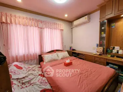 Cozy bedroom with pink decor and built-in wooden storage