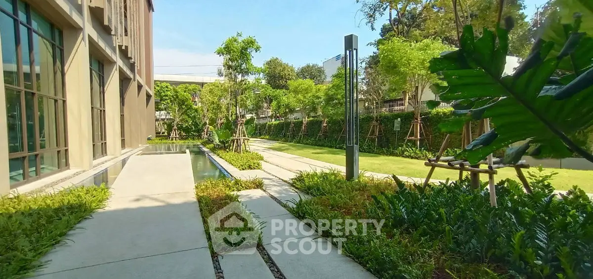 Modern garden with lush greenery and sleek pathways in a contemporary residential complex.
