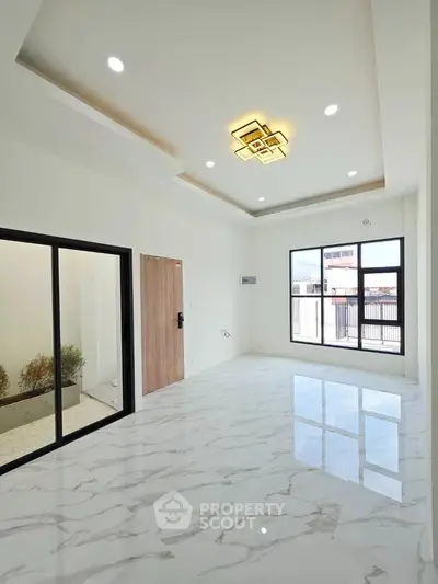 Spacious modern living room with marble flooring and large windows for natural light.