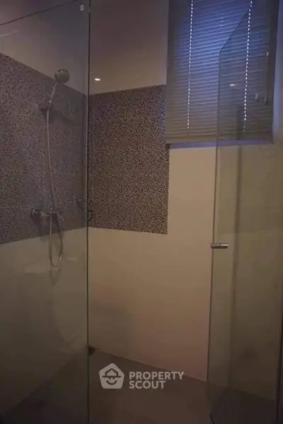 Modern bathroom with glass shower enclosure and stylish tile design.