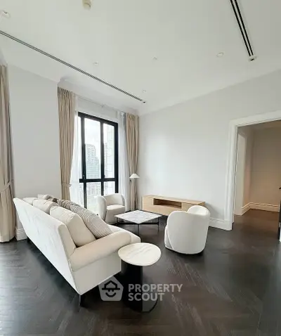 Luxurious living room with elegant furniture and city view, featuring high ceilings and large windows.