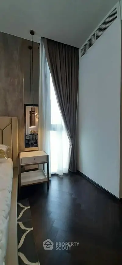 Elegant bedroom with modern decor and floor-to-ceiling window for natural light.