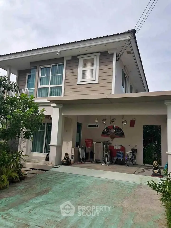 Charming two-story house with spacious driveway and lush greenery, perfect for family living.