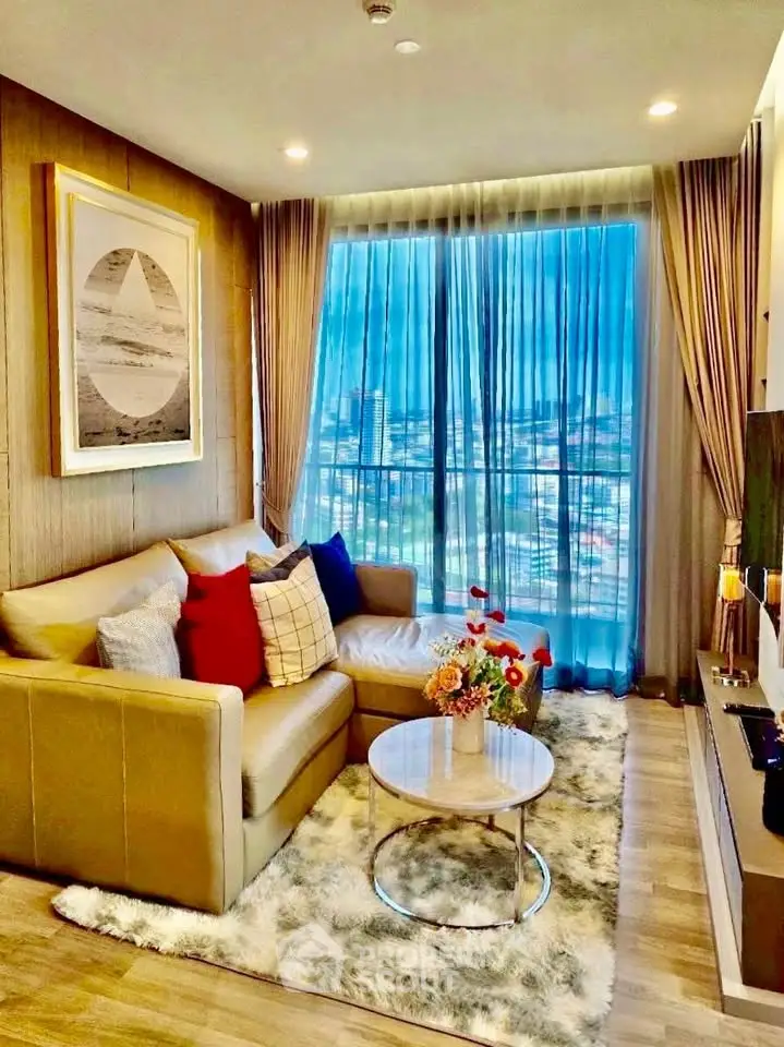 Luxurious living room with plush sofa, chic decor, and panoramic city view through large windows.