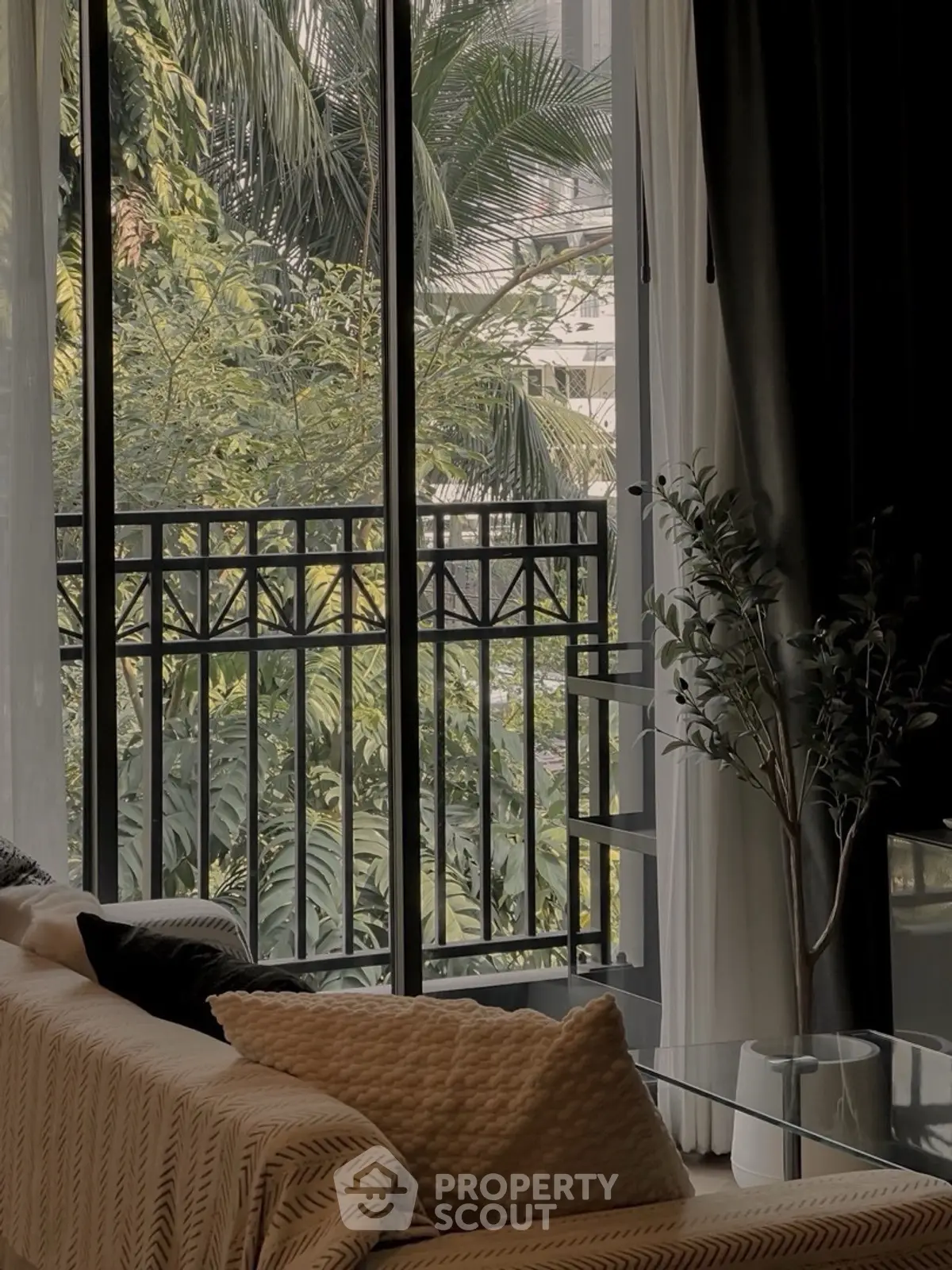 Stylish living room with large window and lush garden view, perfect for relaxation.