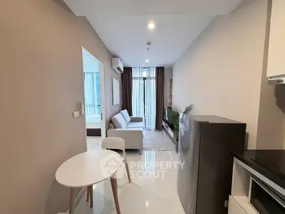 Modern apartment interior with sleek kitchen and cozy living area, featuring stylish furniture and natural light.