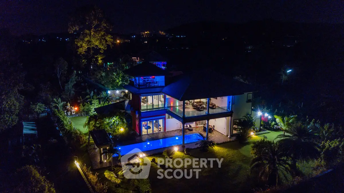 Luxurious modern villa with illuminated pool and lush garden at night, offering a serene and exclusive lifestyle.
