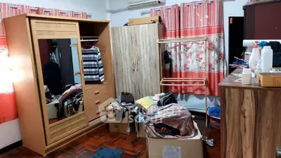 Cozy bedroom with wooden wardrobe and vibrant curtains, perfect for personalizing your space.