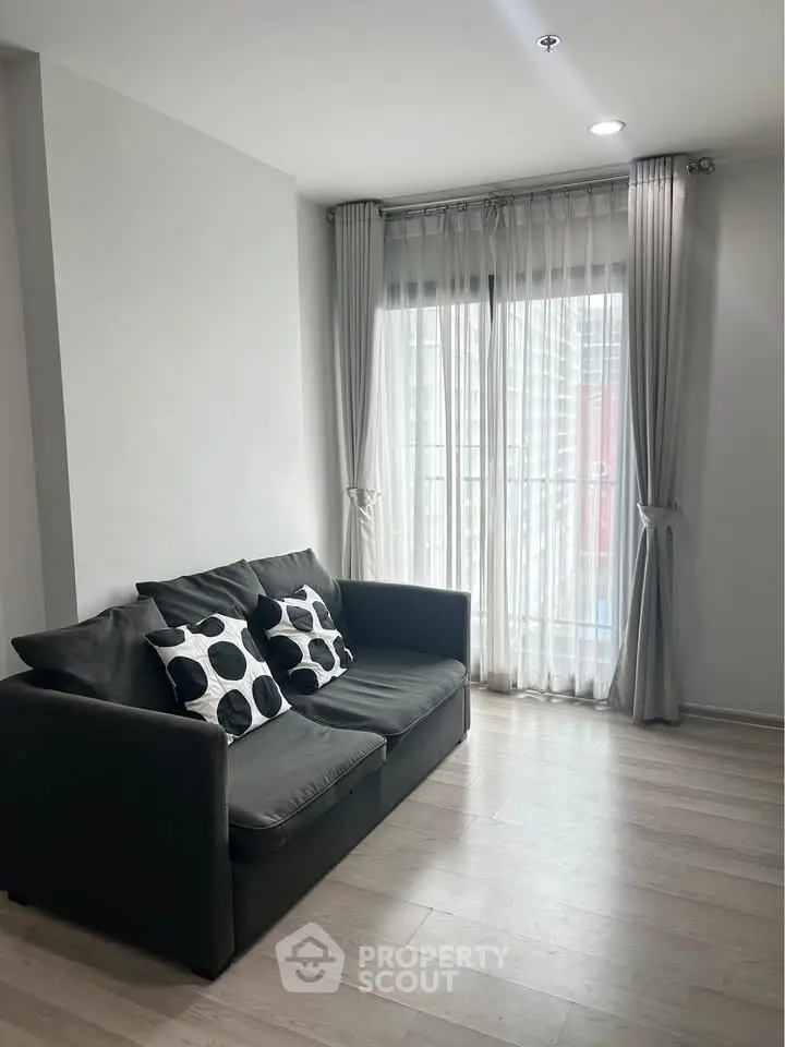 Bright living room with modern sofa and large window, perfect for relaxation.