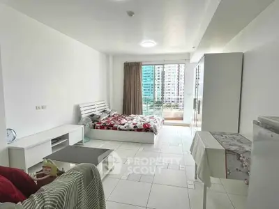 Spacious studio apartment with modern furnishings and city view balcony.