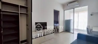 Modern living room with TV, open wardrobe, and air conditioning in a bright apartment.