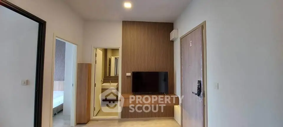 Modern apartment interior with TV, bathroom, and bedroom entrance