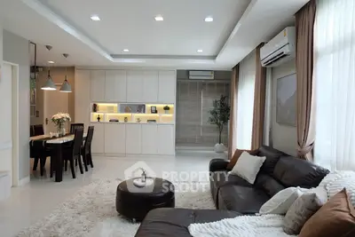 Spacious modern living room with elegant dining area and cozy seating, featuring stylish decor and ample natural light.