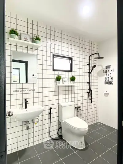 Modern bathroom with sleek fixtures and stylish black and white tile design.