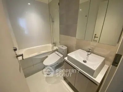 Modern bathroom with sleek fixtures and a bathtub in a contemporary apartment.