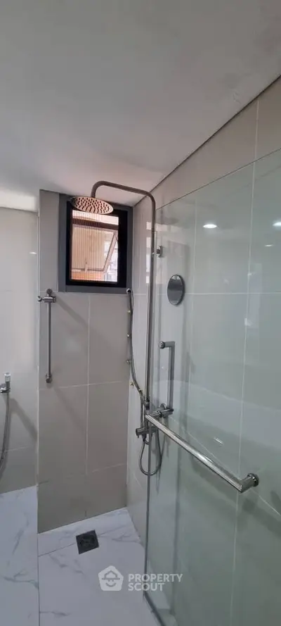 Modern bathroom with glass shower enclosure and rainfall showerhead