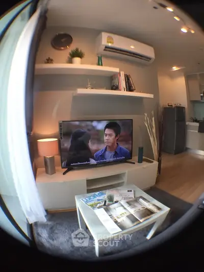 Modern living room with stylish decor and wall-mounted TV in a cozy apartment setting.