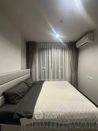 Modern bedroom with cozy bed and elegant curtains in a stylish apartment.
