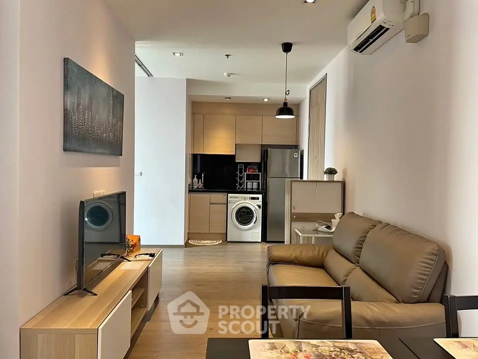 Modern living room with open kitchen and washing machine in stylish apartment.