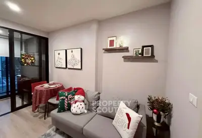 Cozy living room with festive decor and dining area in modern apartment.