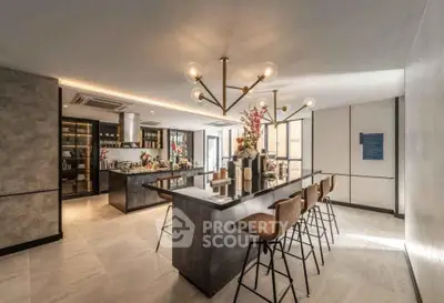 Luxurious modern kitchen with island seating and elegant lighting in a spacious open layout.