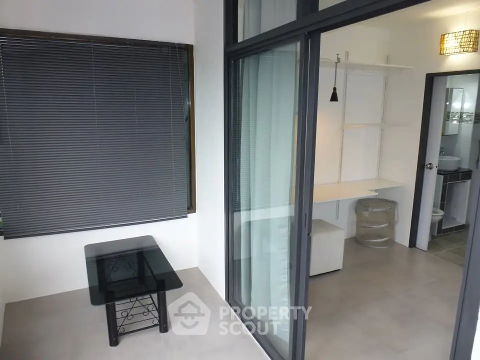 Modern interior with glass table and sliding door, featuring sleek design and ample natural light.