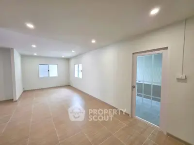 Spacious empty room with tiled flooring and bright lighting, ideal for customization.
